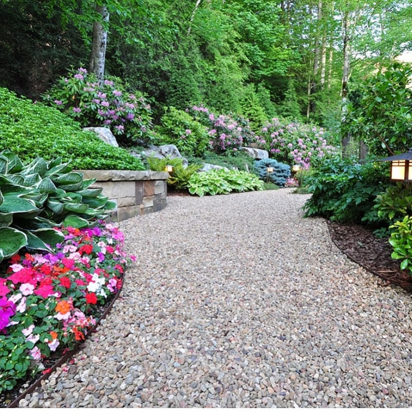 gravel path lined with impatiens and other shade loving plants