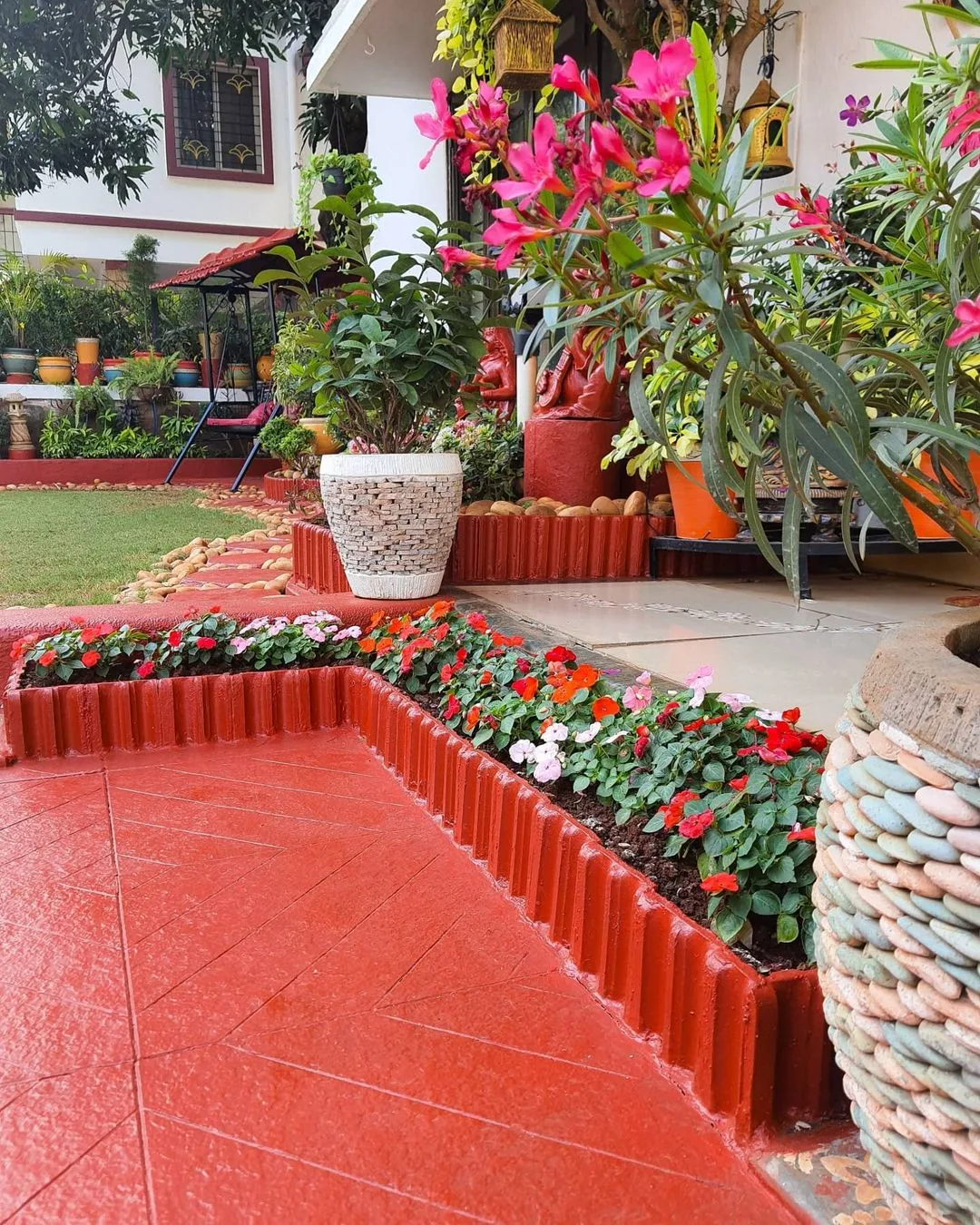 red patio surrounded by red and white impatiens in raised beds