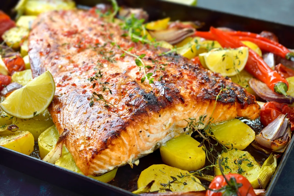 thyme leaves on top of roasted salmon and vegetables