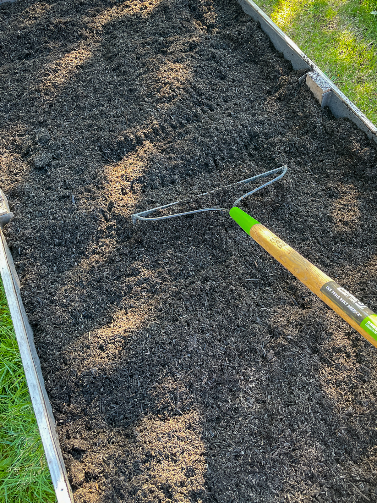 raking compost into a raised bed